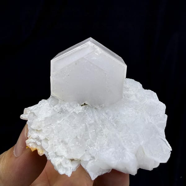 Pale pink hexagonal calcite crystal on white quartz from Fujian, China, detail of the matrix contact