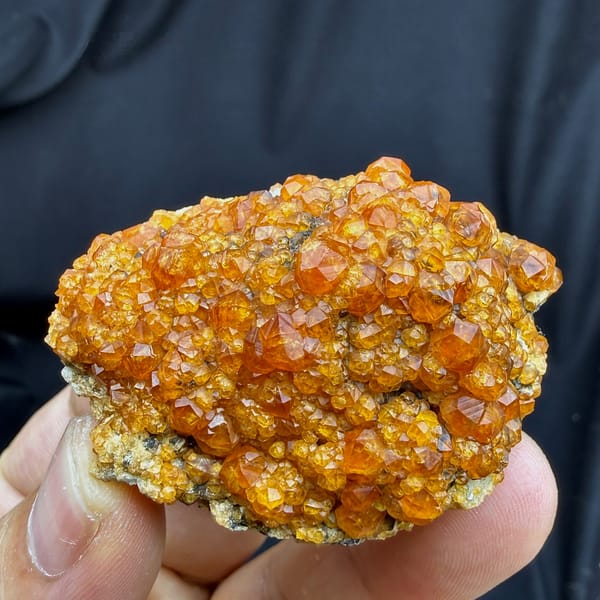Plate of Fanta-orange spessartine garnet crystals from Yunxiao, Fujian, China, detail of the matrix contact