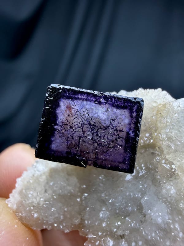 Blue-rimmed purple fluorite cube on white quartz from Inner Mongolia, China, close-up of the crystal faces
