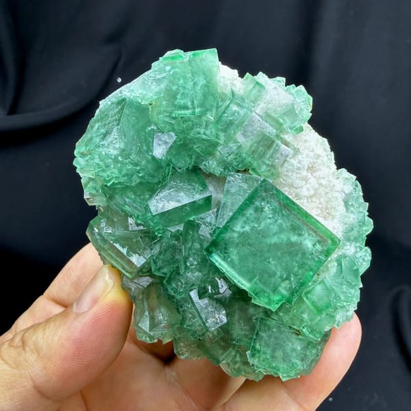 Sea-green daylight fluorite cubes on white quartz from Madagascar, close-up of the crystal faces