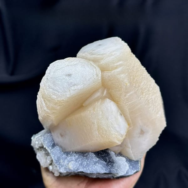 Huge cream calcite prisms with green fluorite and quartz from Fujian, China, held in hand