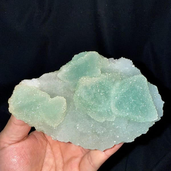 Mint-green sugar-textured octahedral fluorite plate from Fujian, China, held in hand