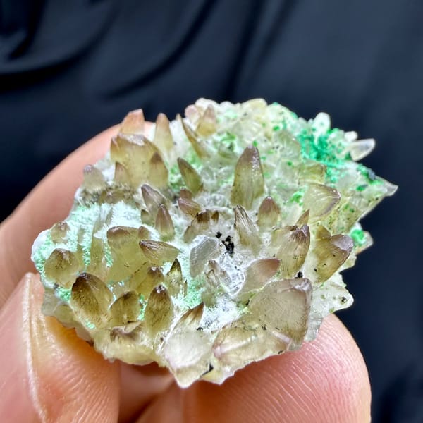 Dogtooth calcite with green copper minerals from Yunnan, China, close-up of the crystal faces