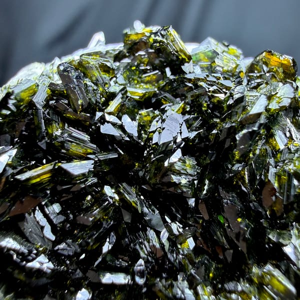 Clear quartz point standing in dark green epidote from Sichuan, China, close-up of the crystal faces