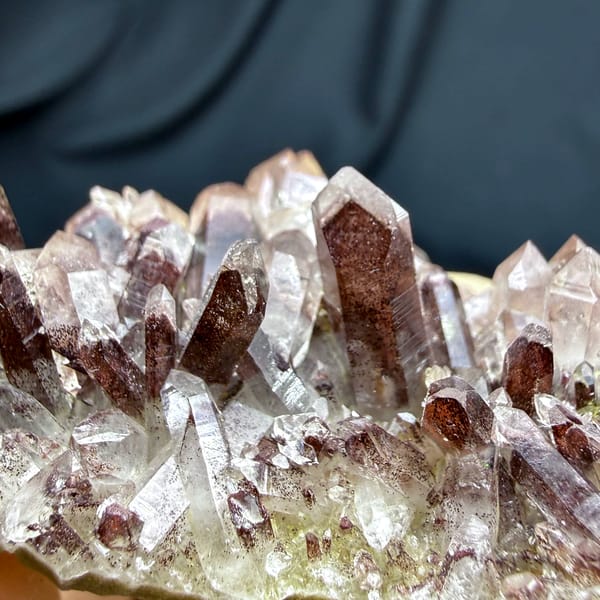 Row of clear quartz points with red hematite phantoms from Shanxi, China, close-up of the crystal faces