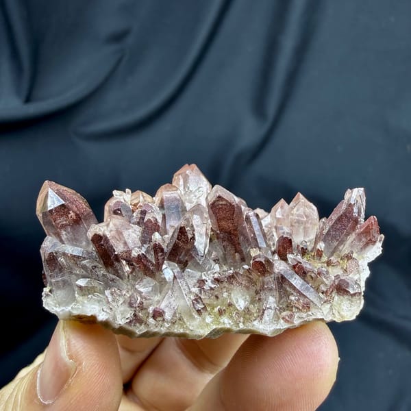 Row of clear quartz points with red hematite phantoms from Shanxi, China, reverse side
