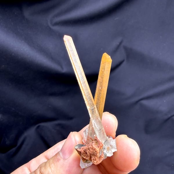 Two orange hematoid quartz needles on specular hematite from Guangdong, China, reverse side