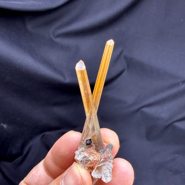 Two orange hematoid quartz needles on specular hematite from Guangdong, China, detail of the matrix contact