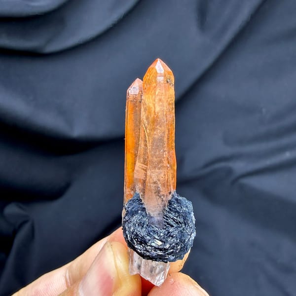 Flame-orange hematoid quartz crystal on black specular hematite from Guangdong, China, detail of the matrix contact