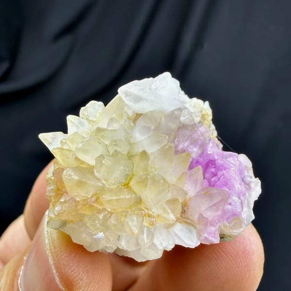 Yellow dogtooth calcite with pink cobalt aragonite from Yunnan, China, held in hand
