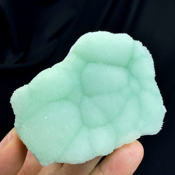 Pastel-green botryoidal aragonite plate from Yunnan, China, close-up of the crystal faces