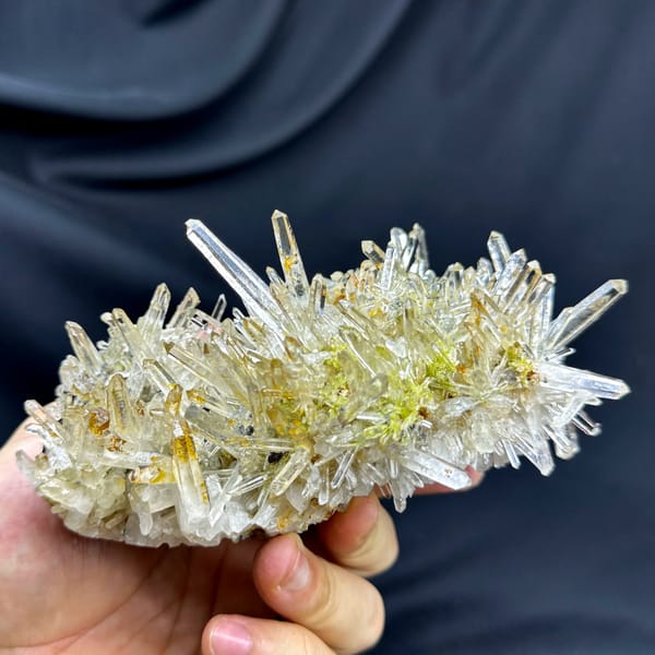 Burst of clear quartz needles with epidote and specular hematite from Guangdong, China, close-up of the crystal faces