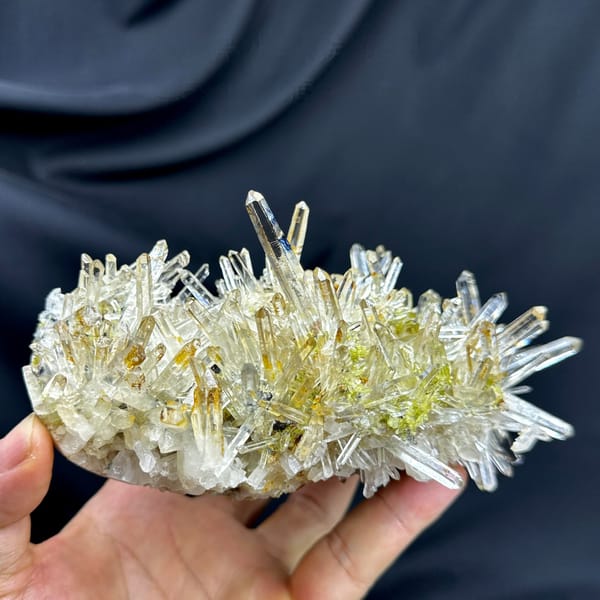 Burst of clear quartz needles with epidote and specular hematite from Guangdong, China, detail of the matrix contact