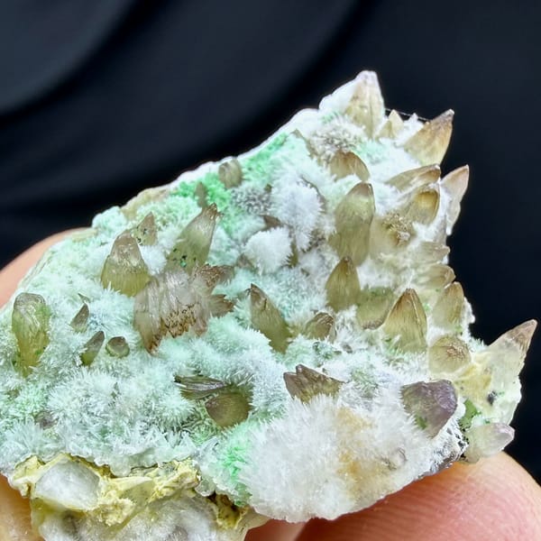Amber dogtooth calcite with green copper minerals and aragonite from Yunnan, China, close-up of the crystal faces