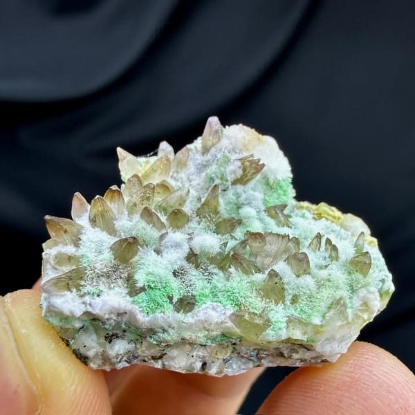Amber dogtooth calcite with green copper minerals and aragonite from Yunnan, China, detail of the matrix contact