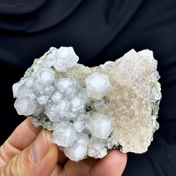 Hexagonal calcite crystals with champagne apophyllite from Fujian, China, held in hand