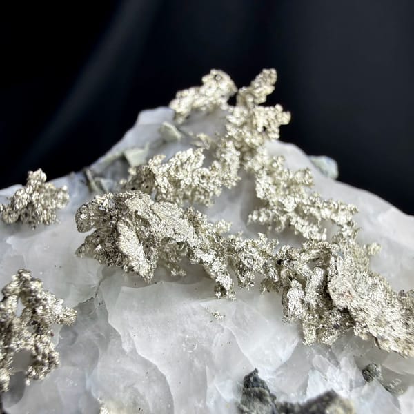 Native silver wires on white calcite from the USA, close-up of the crystal faces