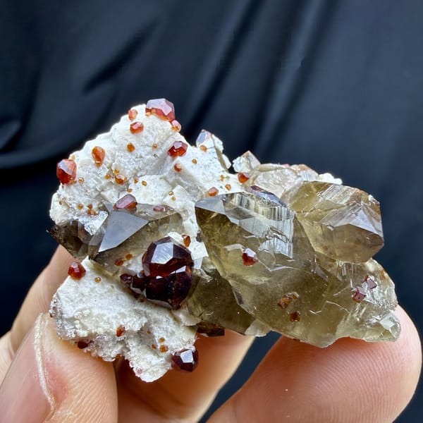 Smoky quartz with red garnets and hyalite opal on feldspar from Yunxiao, Fujian, China, detail of the matrix contact