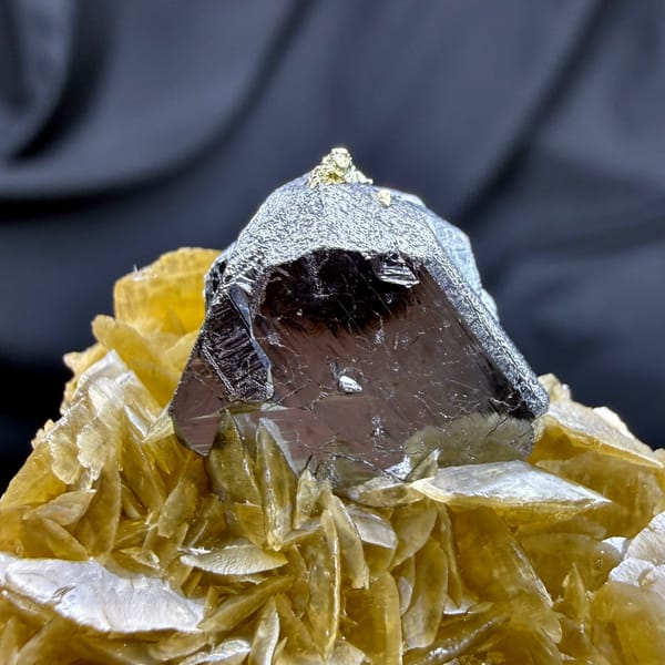 Steel-grey tetrahedrite crystal on golden siderite with chalcopyrite from Guizhou, China, close-up of the crystal faces