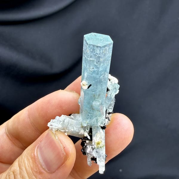 Sea-green aquamarine prism with black schorl on feldspar from Namibia, close-up of the crystal faces