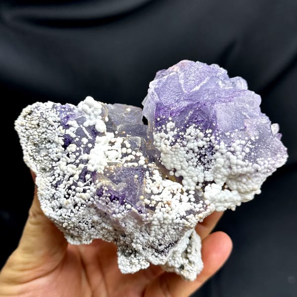 Violet fluorite cubes among white botryoidal aragonite from Yunnan, China, close-up of the crystal faces