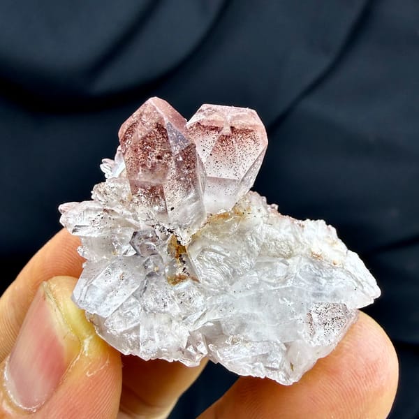 Strawberry-red phantom quartz crystal on white druse from Shanxi, China, close-up of the crystal faces