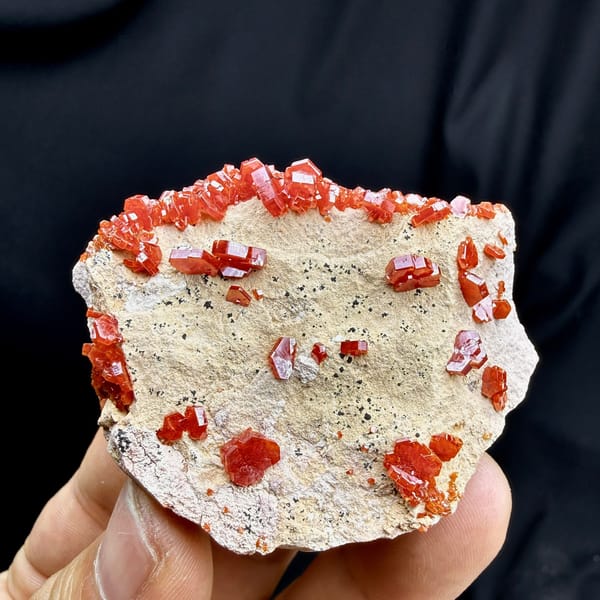 Fiery red vanadinite crystals on pale matrix from Morocco, detail of the matrix contact