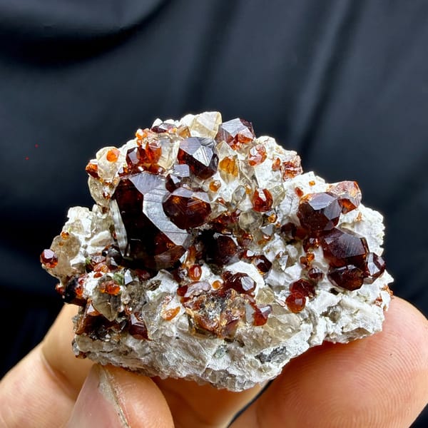 Large dark-red garnet crystals on feldspar and smoky quartz from Yunxiao, Fujian, China, detail of the matrix contact