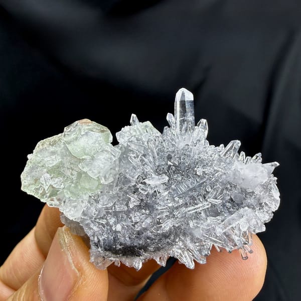 Flat green fluorite with clear quartz needles from Fujian, China, held in hand