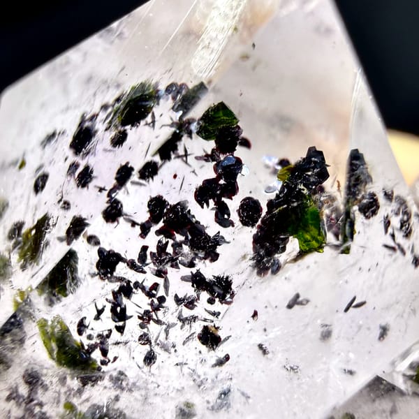 Clear quartz crystals with black-green epidote inclusions from Sichuan, China, close-up of the crystal faces