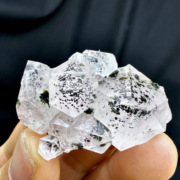 Clear quartz crystals with black-green epidote inclusions from Sichuan, China, detail of the matrix contact