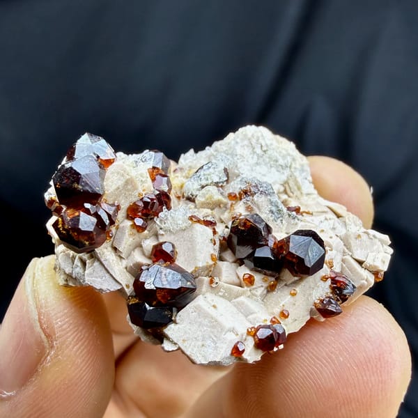 Glossy wine-red garnet crystals with hyalite opal on feldspar from Yunxiao, Fujian, China, reverse side