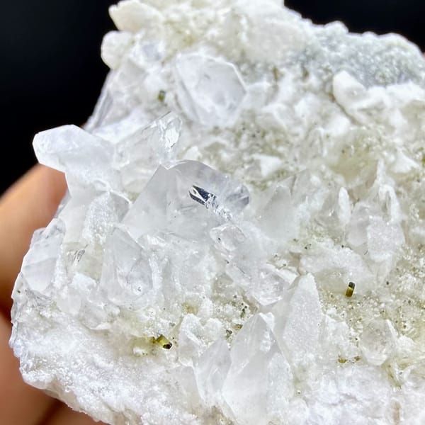 Pale pink feldspar crystal capped with quartz druse and mica from Pakistan, top view