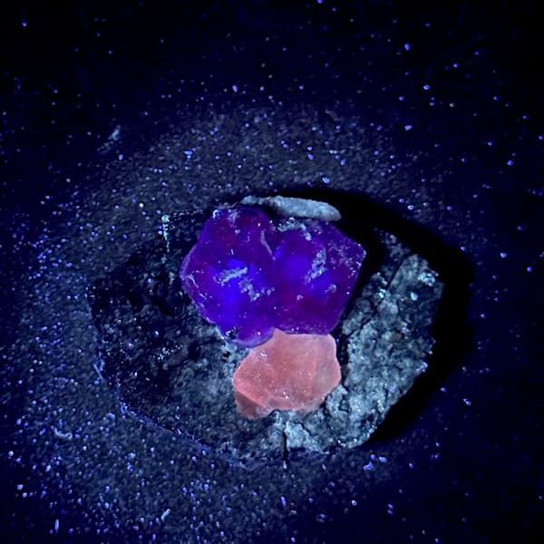 Etched violet-blue fluorite cubes with pale calcite on grey rock from Fujian, China, second angle