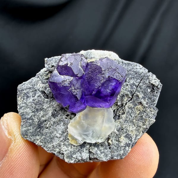 Etched violet-blue fluorite cubes with pale calcite on grey rock from Fujian, China, top view