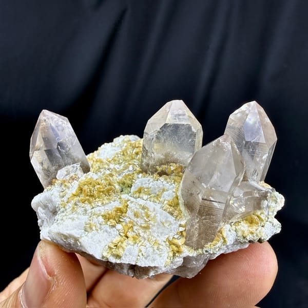 Gradient smoky quartz points on feldspar and mica from Yunxiao, Fujian, China, detail of the matrix contact