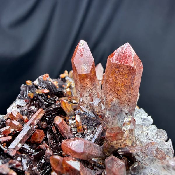 Red-skinned quartz points on specular hematite from Guangdong, China, close-up of the crystal faces