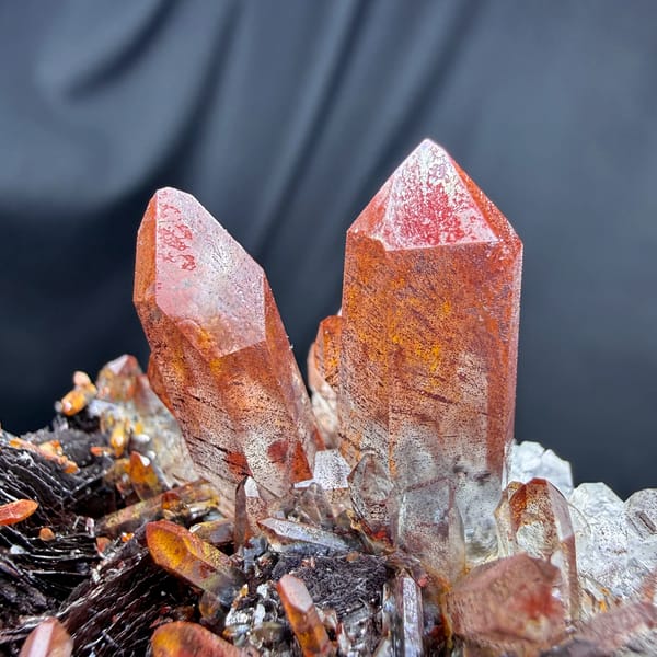 Red-skinned quartz points on specular hematite from Guangdong, China, top view