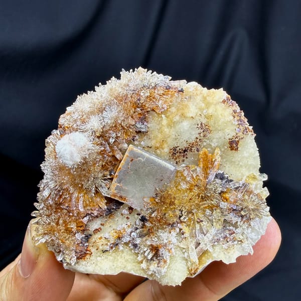 White-rimmed fluorite cube among golden creedite sprays from Guizhou, China, close-up of the crystal faces