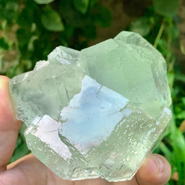 Large transparent green fluorite cube cluster from Fujian, China, held in hand