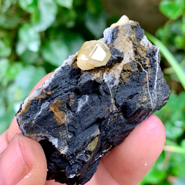 Pale yellow cerussite crystal on dark galena matrix from Guangxi, China, close-up of the crystal faces