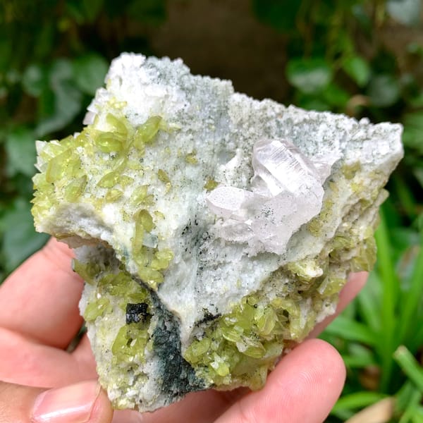 Clear quartz on green chlorite and feldspar with titanite from Pakistan, close-up of the crystal faces