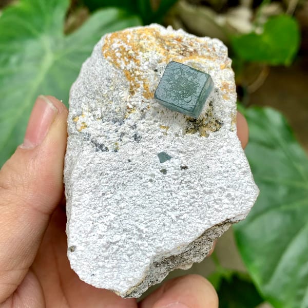 Single green fluorite cube on pale quartz matrix from Inner Mongolia, China, close-up of the crystal faces