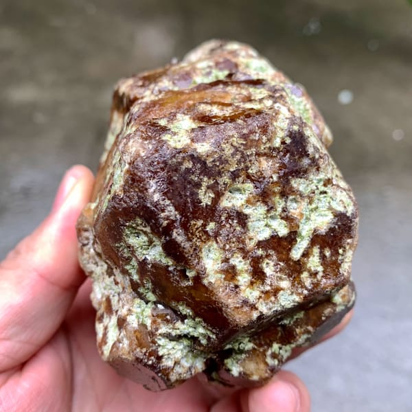 Large brown-green demantoid garnet crystal floater from Mali, close-up of the crystal faces