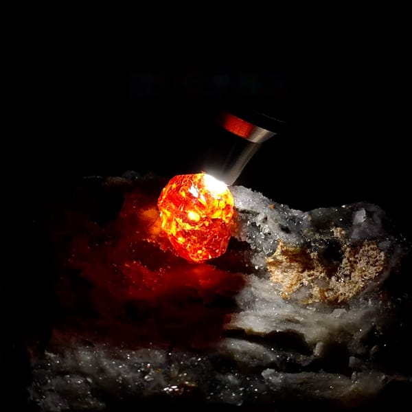 Gem-grade sphalerite crystal glowing orange-red when back-lit, from Hunan, China