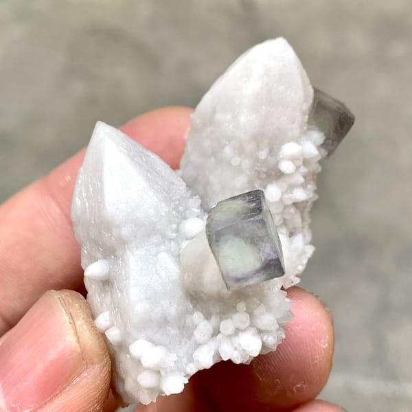 Pale quartz spire with small purple fluorite cubes from Inner Mongolia, China, close-up of the crystal faces