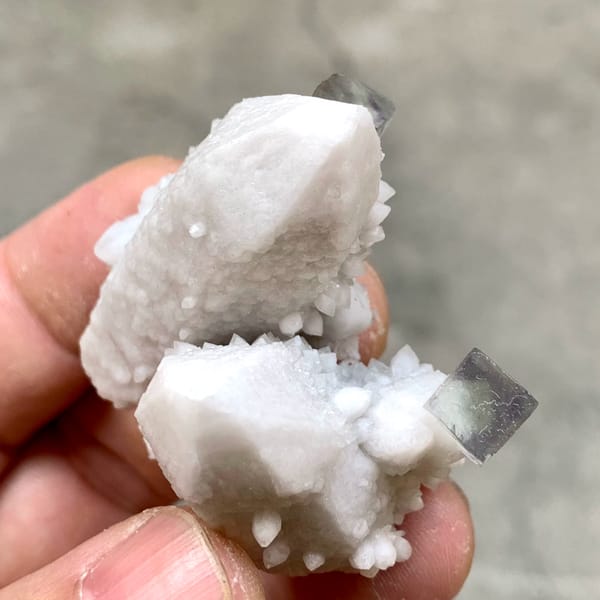 Pale quartz spire with small purple fluorite cubes from Inner Mongolia, China, reverse side