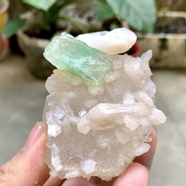 Mint-green apophyllite crystal on pink stilbite from India, detail of the matrix contact