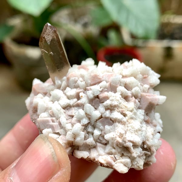 Smoky quartz point on pale feldspar with garnet from Fujian, China, top view