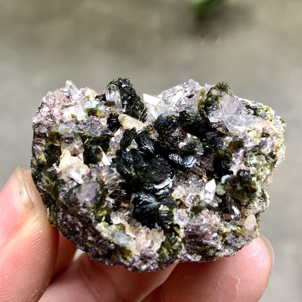 Dark green epidote blades with lilac quartz from Yunnan, China, detail of the matrix contact